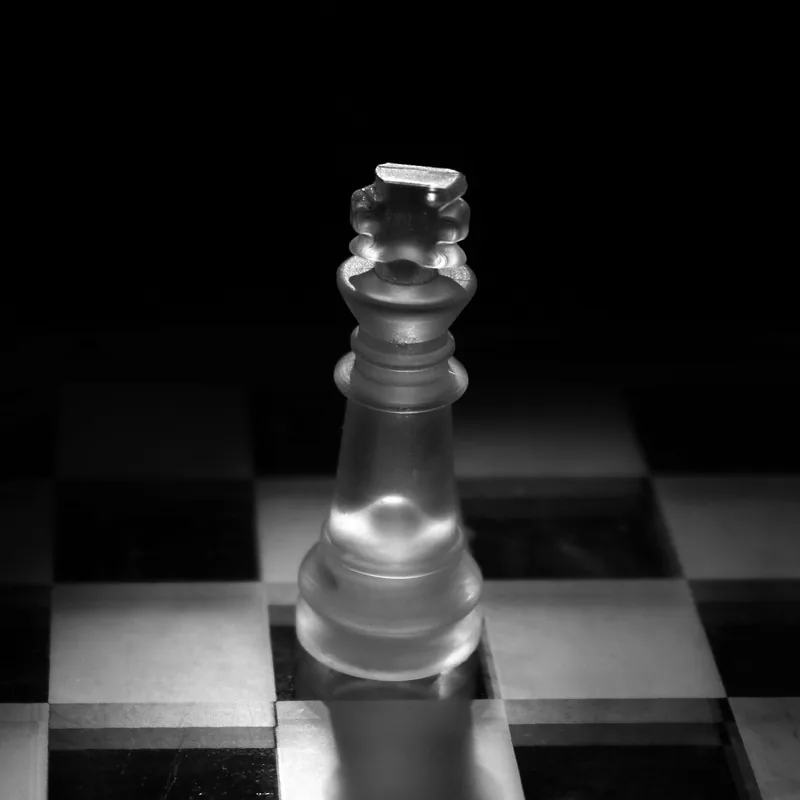 Roi d'un jeu d'échecs en verre sur un échiquier